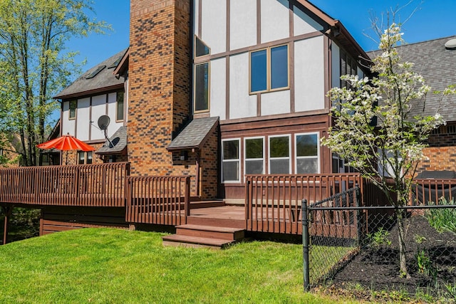 back of property with a wooden deck and a yard