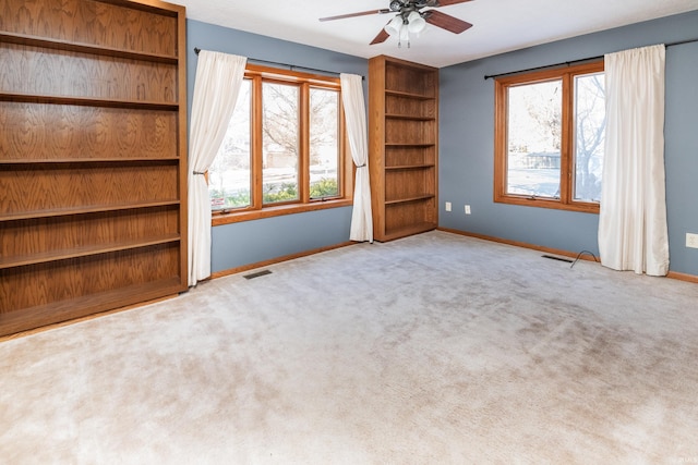 interior space featuring ceiling fan and light colored carpet