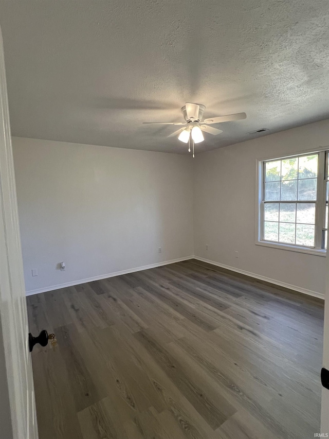 spare room featuring ceiling fan, dark hardwood / wood-style floors, and a textured ceiling