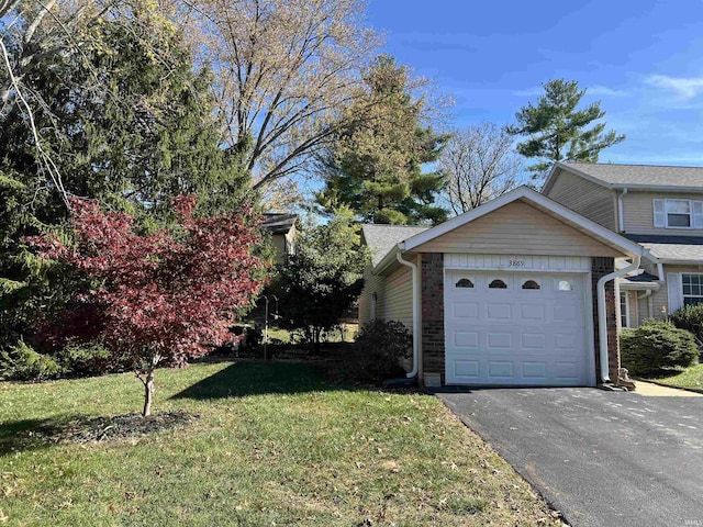 view of side of property featuring a garage and a lawn