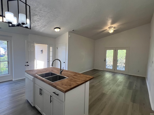 kitchen with butcher block countertops, decorative light fixtures, sink, white cabinets, and white dishwasher