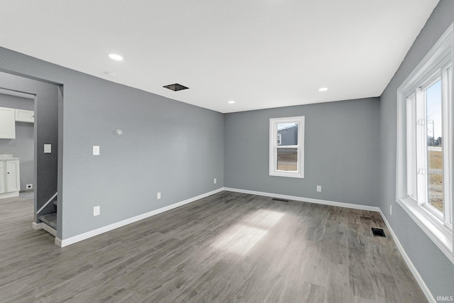 spare room with a healthy amount of sunlight and hardwood / wood-style floors