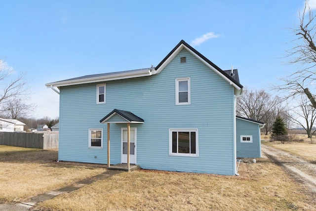 rear view of property with a lawn