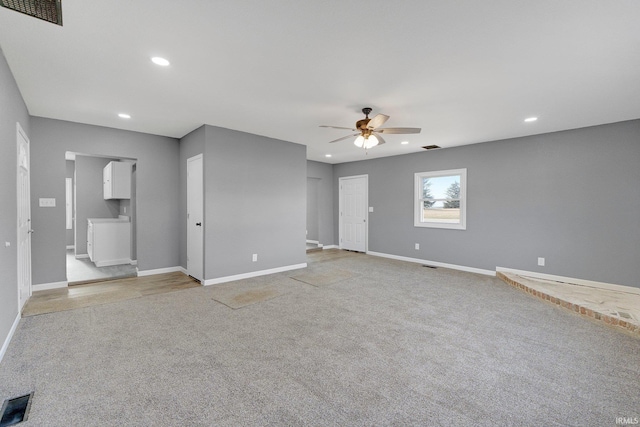 carpeted spare room with washer / dryer and ceiling fan