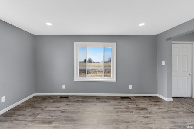 unfurnished room with hardwood / wood-style flooring