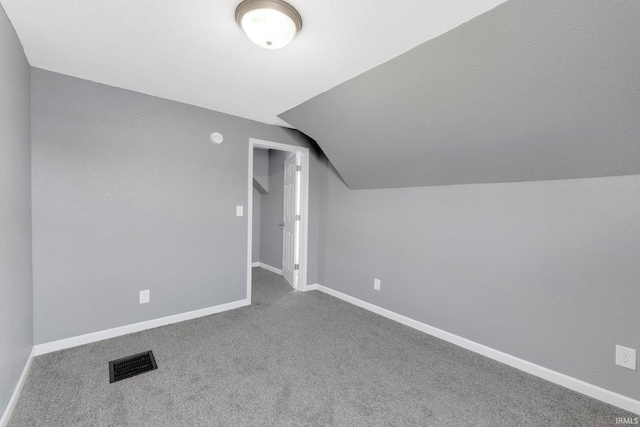 bonus room with lofted ceiling and carpet