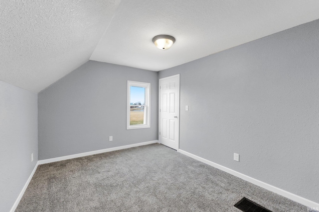 bonus room with carpet flooring, vaulted ceiling, and a textured ceiling