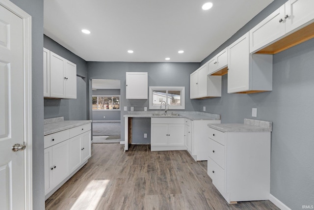 kitchen with sink, white cabinets, and light hardwood / wood-style floors