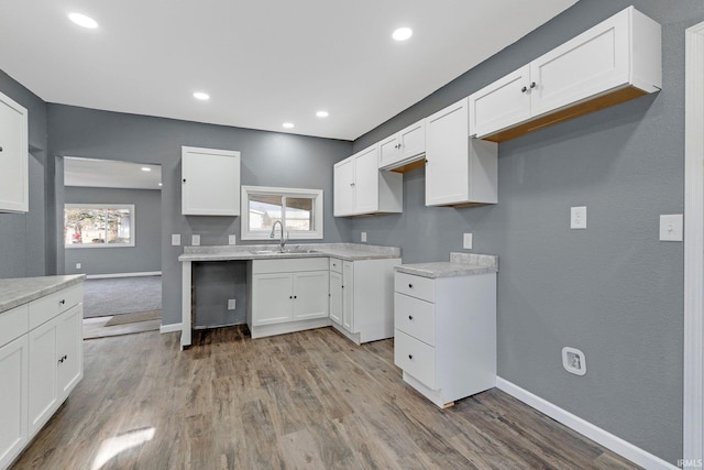 kitchen featuring white cabinetry, sink, and light wood-type flooring