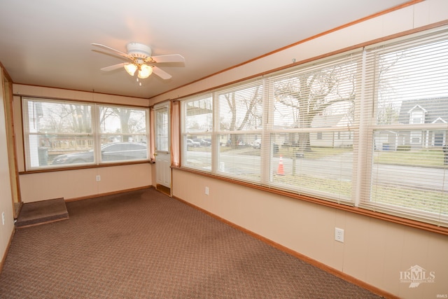 unfurnished sunroom featuring ceiling fan