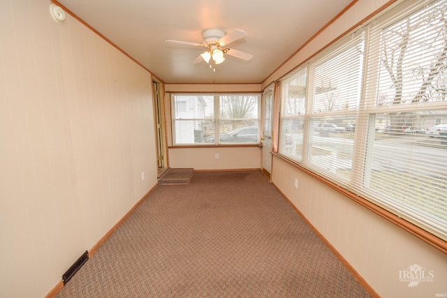 unfurnished sunroom with ceiling fan