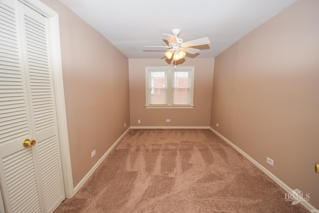 carpeted spare room with ceiling fan