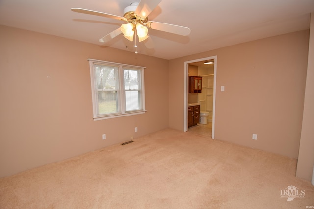 empty room featuring light colored carpet and ceiling fan