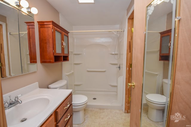 bathroom with walk in shower, vanity, and toilet