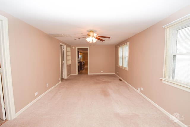 empty room featuring light colored carpet and ceiling fan