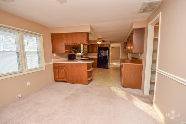 kitchen featuring black appliances, sink, ceiling fan, kitchen peninsula, and light carpet