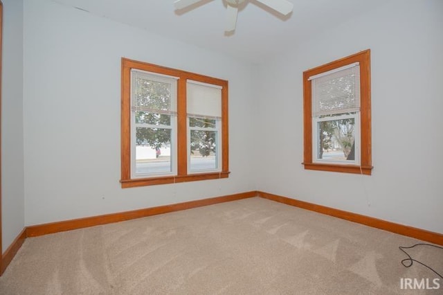 carpeted spare room with ceiling fan