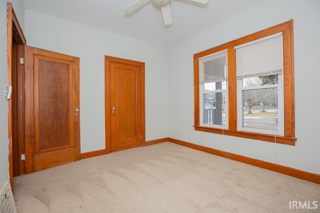 carpeted empty room featuring ceiling fan