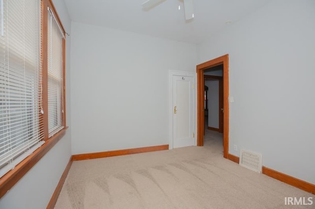 interior space with light carpet and ceiling fan