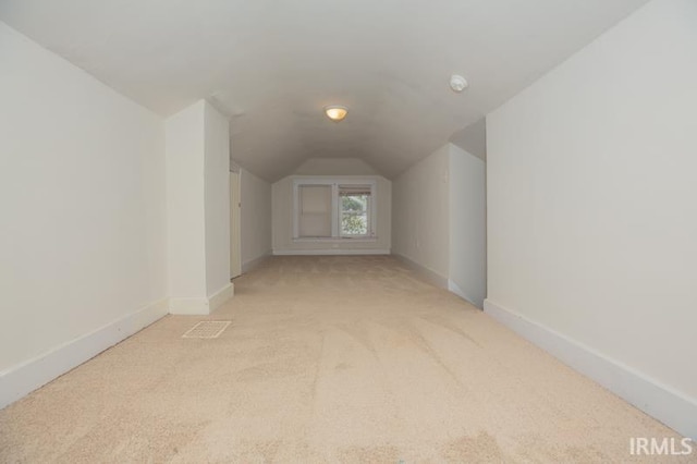 additional living space with lofted ceiling and light carpet