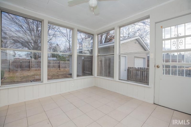 unfurnished sunroom with ceiling fan