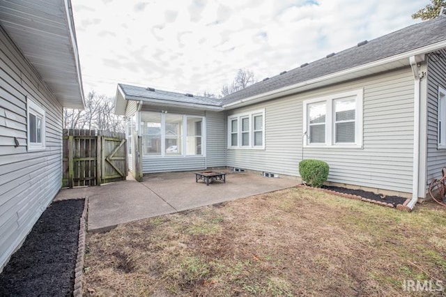 rear view of house with a yard, a patio area, and an outdoor fire pit