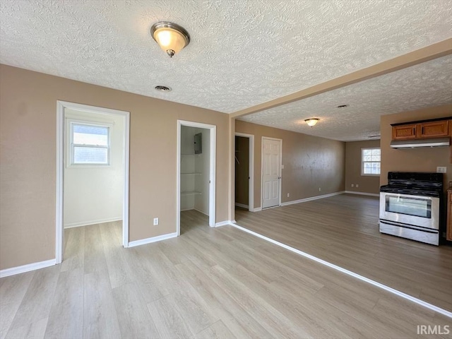 unfurnished living room featuring light hardwood / wood-style flooring and a textured ceiling