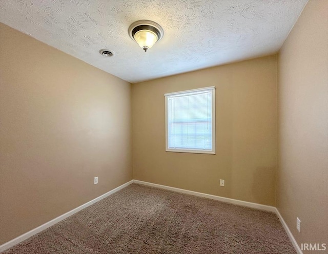 carpeted spare room featuring a textured ceiling