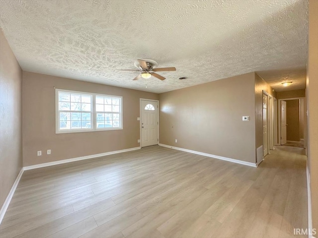 unfurnished room with a textured ceiling, light hardwood / wood-style floors, and ceiling fan