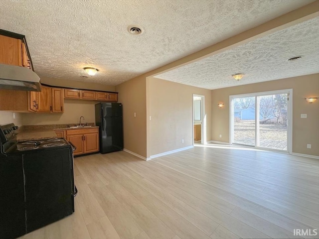 kitchen with sink, black appliances, a textured ceiling, and light wood-type flooring