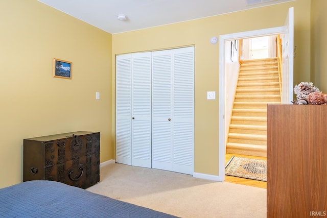 bedroom with light colored carpet and a closet