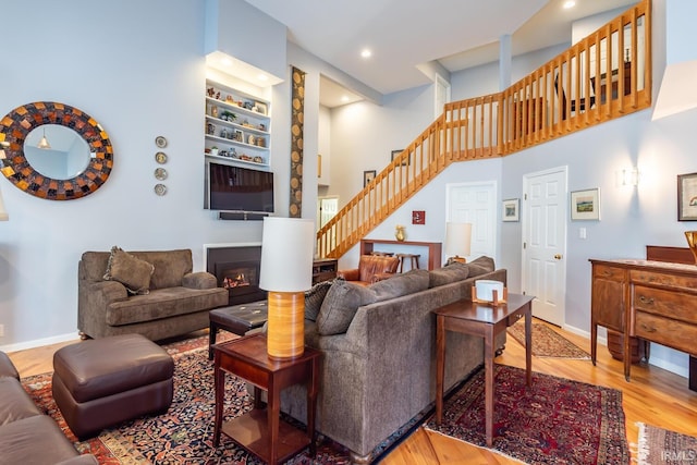 living room with a high ceiling and wood-type flooring