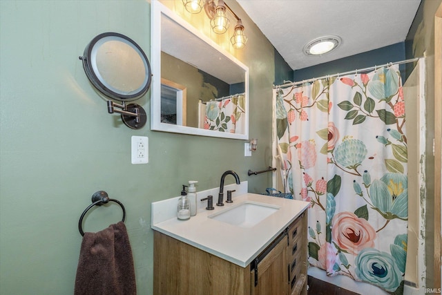 bathroom featuring vanity, curtained shower, and a textured ceiling