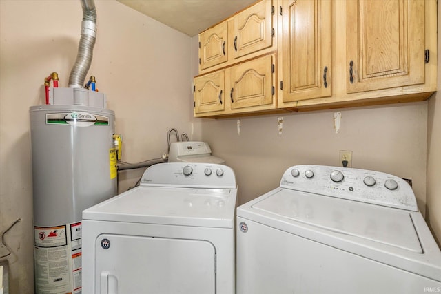 laundry room with water heater, washer and dryer, and cabinets