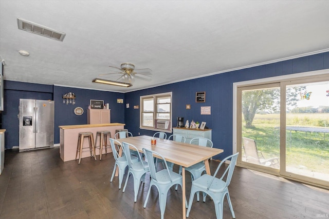 dining space with dark wood-type flooring, ceiling fan, a healthy amount of sunlight, and crown molding