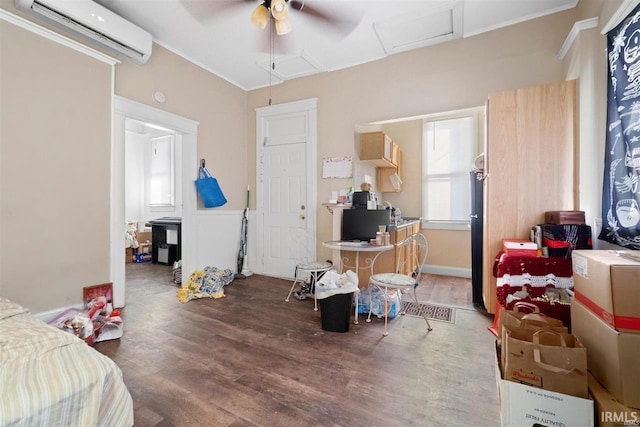 bedroom featuring a wall mounted air conditioner, hardwood / wood-style flooring, ornamental molding, and black fridge