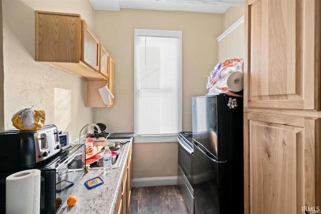 kitchen with sink, fridge, dark hardwood / wood-style floors, light stone counters, and light brown cabinetry