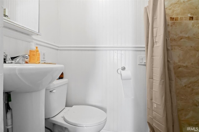 bathroom featuring toilet and a shower with shower curtain