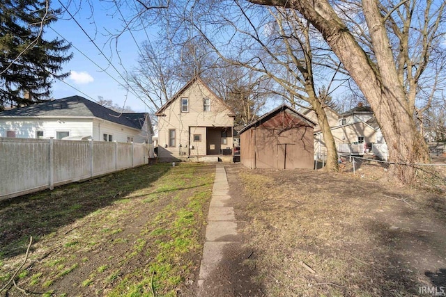 rear view of property featuring a shed