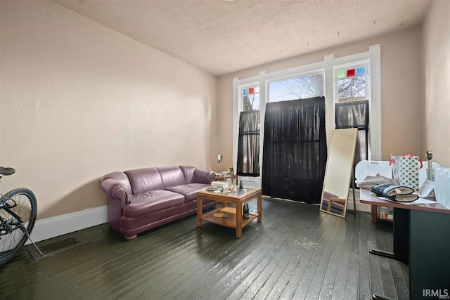 living room featuring dark wood-type flooring and a textured ceiling