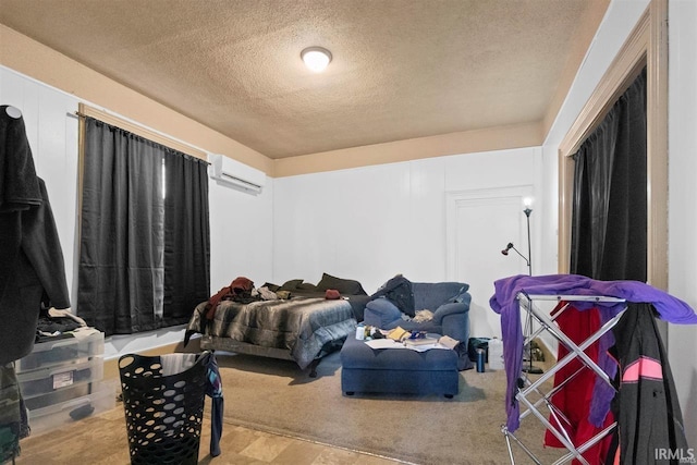 bedroom featuring a wall unit AC and a textured ceiling