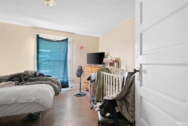 bedroom featuring wood-type flooring and a textured ceiling