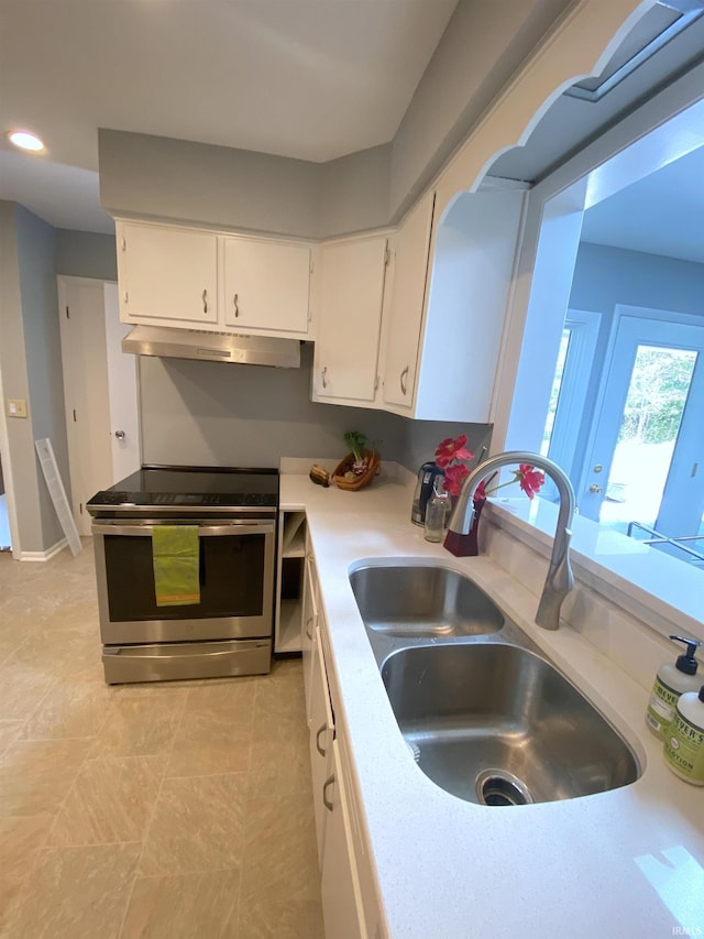 kitchen with stainless steel range with electric stovetop, sink, and white cabinetry