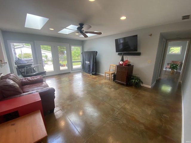 living room featuring ceiling fan and a skylight