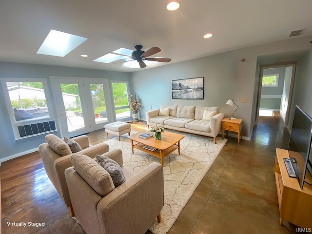 living room with a skylight, plenty of natural light, and ceiling fan