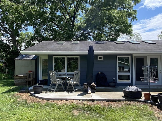 back of house featuring a storage shed and a patio