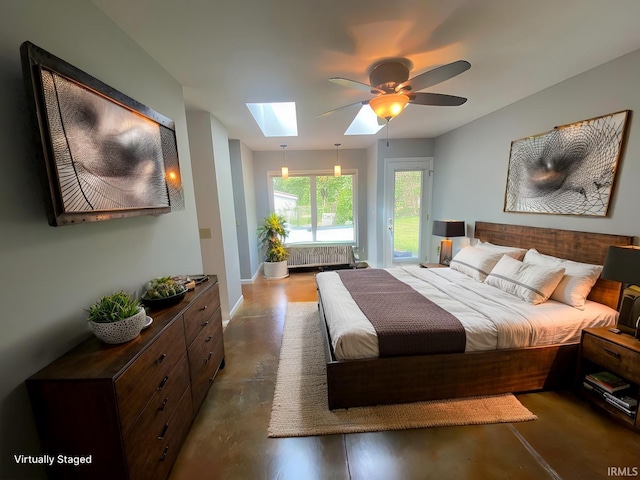 bedroom with radiator, access to outside, ceiling fan, and a skylight