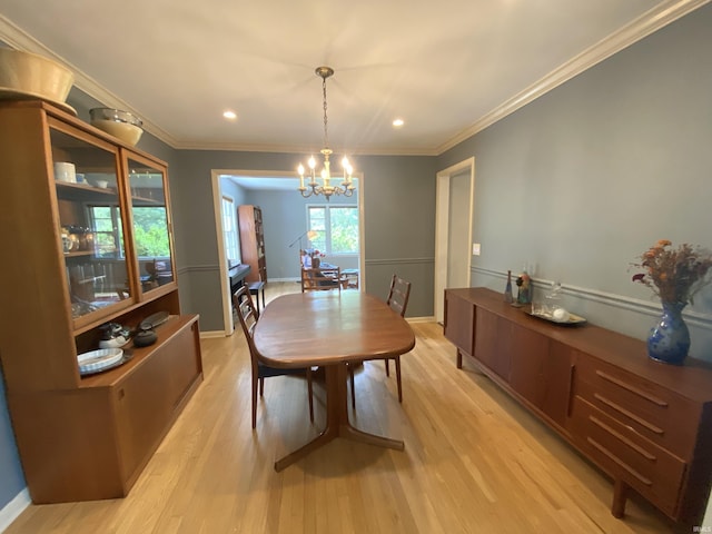 dining room with an inviting chandelier, ornamental molding, and light hardwood / wood-style flooring