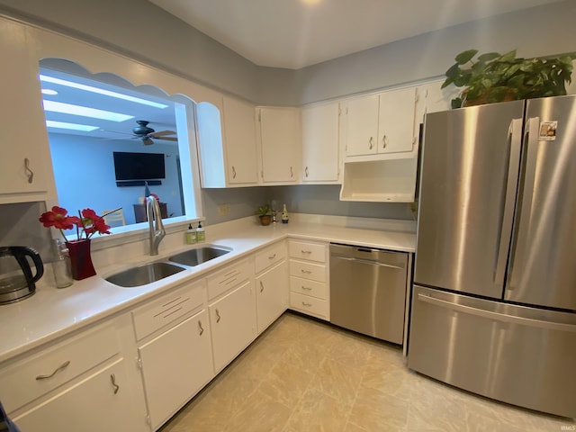 kitchen featuring ceiling fan, stainless steel appliances, sink, and white cabinets