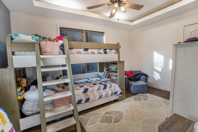 bedroom featuring a tray ceiling, ceiling fan, and hardwood / wood-style flooring